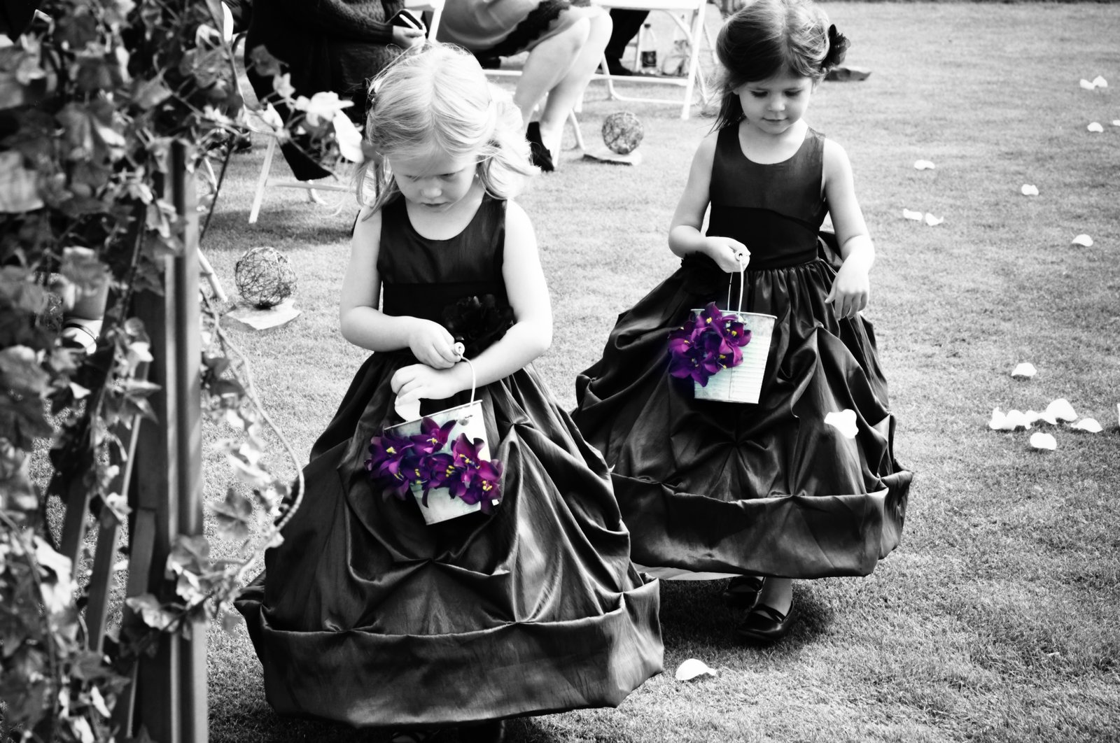 Flower girls walking the aisle with purple petals